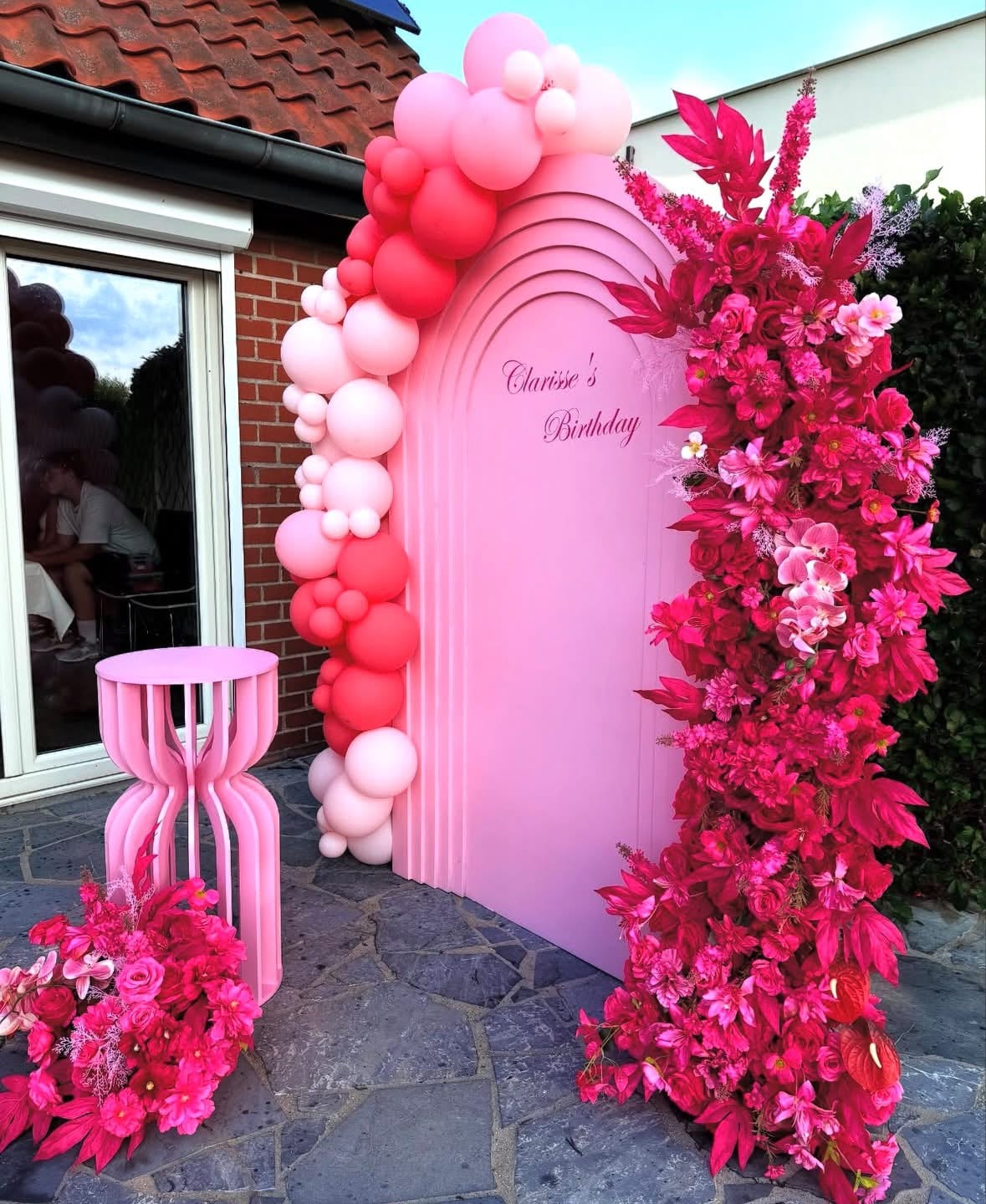 Arche rose, ballons et cascade de fleurs fuchsia pour un anniversaire