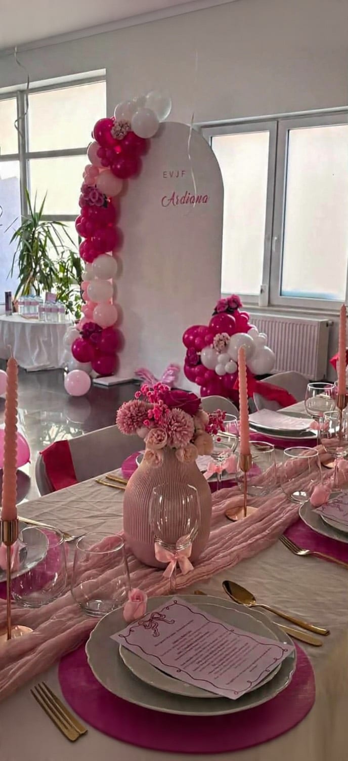 Table dressée et arche de ballons roses pour un EVJF
